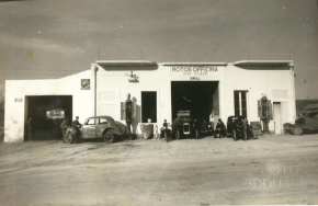 L'officina F.lli Tiani nel 1970: la facciata, le auto dell'epoca e le persone davanti alle saracinesche